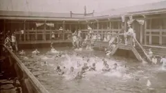 Imagem antiga de pessoas nadando em uma piscina coletiva