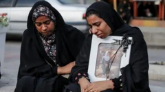 Dve ženski sta jokali, medtem ko sta v rokah držali fotografije otrok, ki so bili žrtve napada.