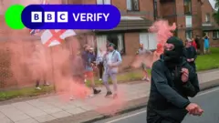 A demonstrator throws a smoke flare at police in Sunderland