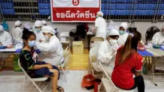Women receive the Sinovac coronavirus disease (COVID-19) vaccine as the Thai resort island of Phuket rushes to vaccinate its population amid the COVID-19 outbreak ahead of a July 1 end of strict quarantine for overseas visitors to bring back tourism revenue, in Phuket