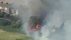 লন্ডনের পূর্বে ওয়েনিংটনে তাপদাহের মধ্যে মাঠের ঘাসে এবং ঝোপ-ঝাড়ে আগুন ধরে গেছে