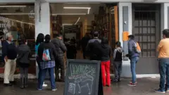 customers waiting to enter the shop