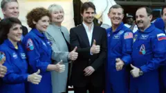 Cruise posed with astronauts after narrating a documentary about the ISS in 2002