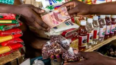 Mano en una tienda pagando a otra con francos