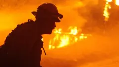 Firefighters try to extinguish Dixie Fire near Chico in Greenville, California, United States on August 5, 2021.