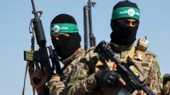 Palestinian fighters from the armed wing of Hamas take part in a military parade to mark the anniversary of the 2014 war with Israel, near the border in the central Gaza Strip on 19 July 2023.