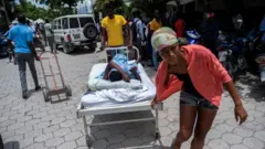 Umugore wakomerekeye mu mutingito wo ku wa gatandatu wo ku gipimo cya 7.2 atwawe ku gitanda cyo mu ajyanwa ku bitaro, mu mujyi wa Les Cayes, Haïti, ku itariki ya 16/8/2021.