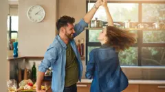 Un couple en train de danser chez eux