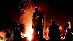 People gathered around a camp fire