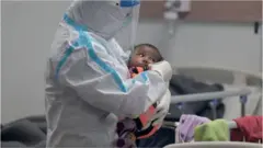 A health worker comforts a child with Covid-19