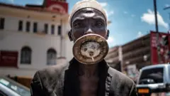 አማራጭ የፊት ጭምብል ያጠለቀ ሰው