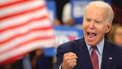 Joe Biden clenching his fist and shouting on stage.