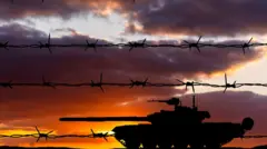 Броньований танк на фоні колючого дроту