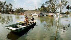 Dois homens remando nas águas da enchente em Nova Orleans, depois que o furacão Katrina devastou a área, em 31 de agosto de 2005
