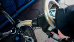 Una manguera de gasolina en un depósito de un auto