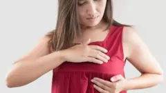 స్తన్యాన్ని పరీక్షించుకొంటున్న ఒక మహిళ