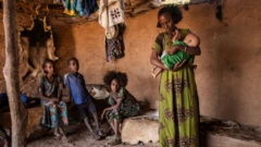 በትግራይ ክልል አንዲት እናት ልጇን ታቅፋ 
