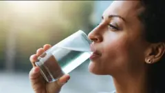 Umugore ariko anywa amazi mu kirahuri