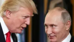 US President Donald Trump (L) dey chat wit Russia President Vladimir Putin as dem attend di APEC Economic Leaders' Meeting, part of di Asia-Pacific Economic Cooperation (APEC) leaders' summit for di central Vietnamese city of Danang on November 11, 2017.