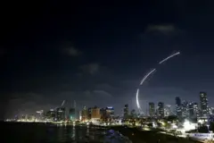 Rajadas de luz atrás de prédios durante a noite