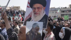 Pro-government demonstrators hold up a photograph of the Supreme Leader