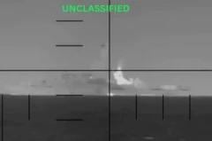 تصویری سیاه و سفید و مدرج که به نظر مربوط به دوربین جنگی باشد، در دوردست ناوی را نشانه گرفته است، روی تصویر نوشته شده طبقه‌بندی نشده