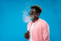 Un homme qui fume une cigarette électronique.