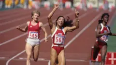 Florence Griffith-Joyner ao lado de duas concorrentes, vencendo uma corrida durante os Jogos Olímpicos de 1988 em Seul, na Coreia do Sul