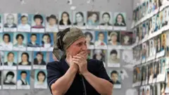 Mulher chorando ao ver as fotos das vítimas do ataque no ginásio da escolalucky slots 777Beslan.