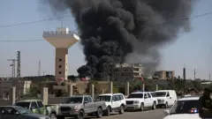 Uma coluna de fumaça preta capturada à distância perto de Sweida, na Síria, em 15 de julho de 2025