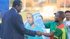 የፌዴሬሽኑ ፕሬዝደንት ኢሳያስ ጅራ ለሽመልስ ሽልማት ሲያበረክቱ