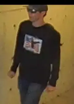 Homem com boné, camisa preta e óculos escuros subindo a escada