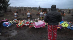 Dima looks at the graves of his mum, dad and grandparents