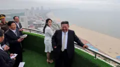 Kim Jong-un e sua filha Kim Ju-ae posam em uma varanda à beira-mar durante uma cerimônia para celebrar a conclusão da Zona Turística Costeira de Wonsan Kalma, em Wonsan, Coreia do Norte, em 24 de junho de 2025.