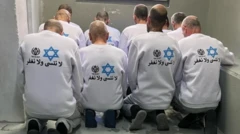 سجناء فلسطينيون يرتدون قمصاناً تحمل شعار مصلحة السجون الإسرائيلية وعبارة "لن نغفر ولن ننسى"، نشرتها مصلحة السجون يوم السبت