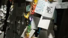 哀悼者摆放的摺纸，伴着一张纸写上“冤”纸条。