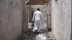 Aworan ọkunrin kan to wọ aṣọ adura, to n rin lọ ninu ile ijọsin ti wọn jo nina