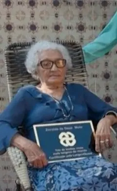 Uma idosa segurando uma placa de recorde