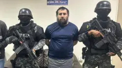 Alias Fito junto a dos miembros de la Policía de Ecuador. 