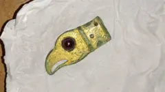 Фрагмент ременя у вигляді голови хижого птаха, датований IV-V століття