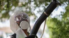 Людина в захиснову одязі ловить комарів