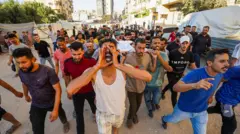 فلسطينيون ينوحون على جثامين القتلى الذين نُقلوا من مشرحة مستشفى العودة لدفنهم بعد غارة إسرائيلية استهدفت مدنيين تجمعوا خارج المستشفى لتشييع جثامين فلسطينيين آخرين، في جباليا، غزة، فلسطين، في 17 يوليو/تموز 2026