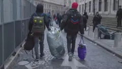 쓰레기를 들고 가는 두 남성