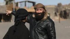 أحمد العودة، قائد القوات الموالية للحكومة السورية الجديدة، يلوح بيده في بلدة بصرى في محافظة درعا جنوب سوريا، بعد أيام من سقوط النظام.