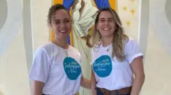 La empleada bancaria Pamella Silva Barbosa Silva (cabello rizado) y su prometida en eventos de la iglesia: una pareja de dos mujeres con camisetas blancas y jeans azules, frente a una imagen religiosa y flores.