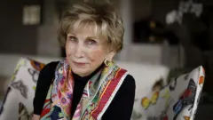 Едіт Еґер в яскравому шалику на фоні темного светра