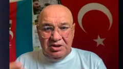 Видади Искандерли на фоне азербайджанского и турецкого флагов.