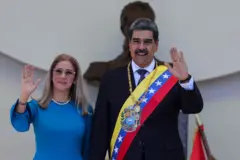 Bà Cilia Flores mặc váy xanh và vẫy tay chào đám đông, bên cạnh chồng bà là Nicolás Maduro