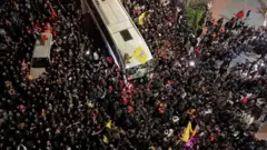 Centenas de pessoas cercando os ônibus trazendo prisioneiros palestinos libertados