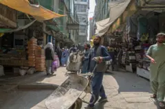 مردی که کراچی بدست آورد و در جستجوی کار در کنار جاده ایستاده است. 